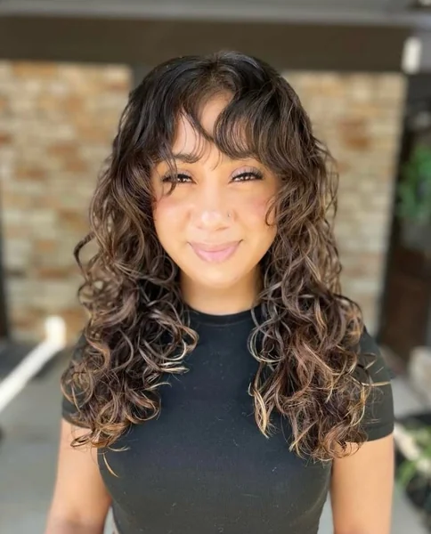 20 Butterfly Haircut for Curly Hair 2026 That'll Make Strangers Stop You on the Street (Number 7 Is Insane!) 3 Curly Brunette Butterfly Cut with Trendy Curtain Bangs