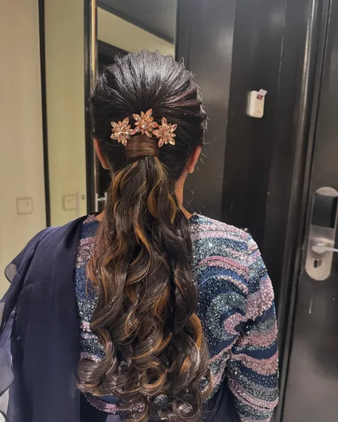 Embellished Low Ponytail with Copper Highlights and Curls