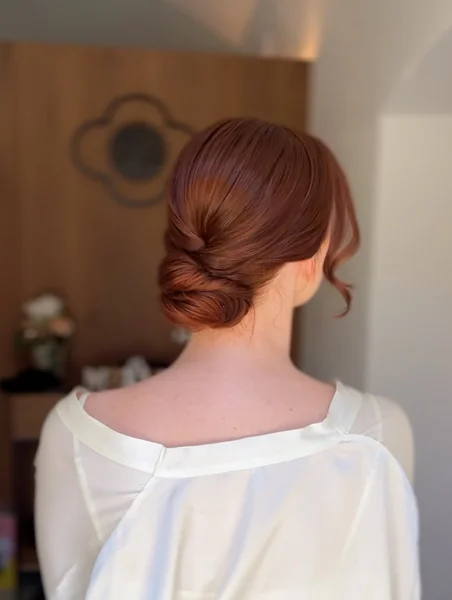 Polished Twisted Auburn Low Bun with Volume
