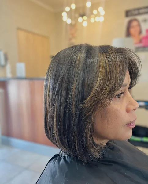 Sleek Brunette Bob with Sun-Kissed Face-Framing Bangs