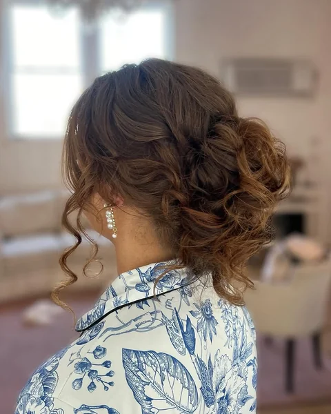 Elegant Brunette Chignon with Deep Side Part and Tendrils