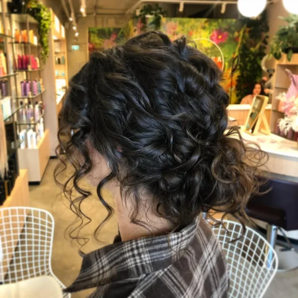 Relaxed Brunette Low Bun with Face-Framing Tendrils