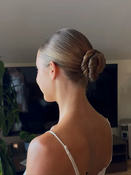 Sleek Glass-Finish Low Bun with Intricate Braided Knot