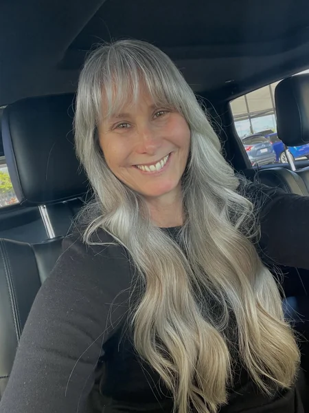 Long Wavy Gray-Blonde Hairstyle with Bangs