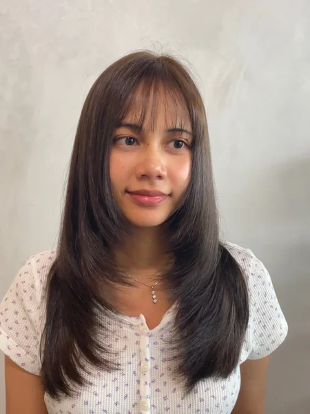 Oval Layered Haircut with Face-Framing Bangs