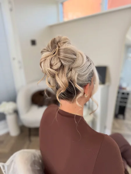 High Messy Bun with Wispy Curls