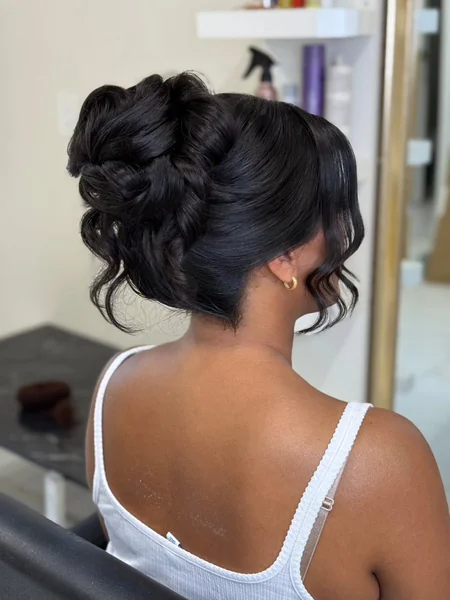 Curly High Bun with Face-Framing Strands