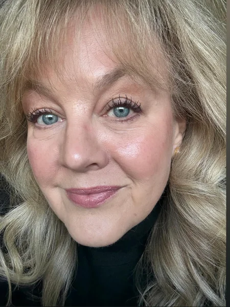 7. Feathered Blonde Waves with Full Fringe