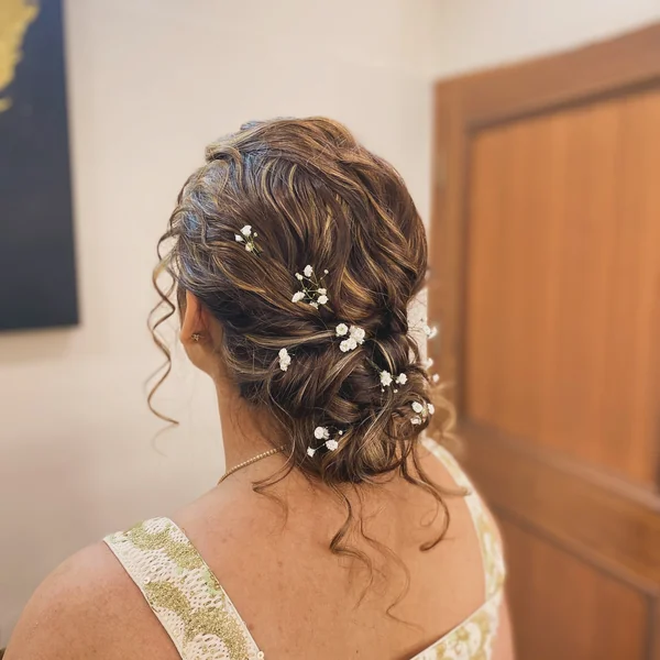 Boho Curly Low Bun with Flowers